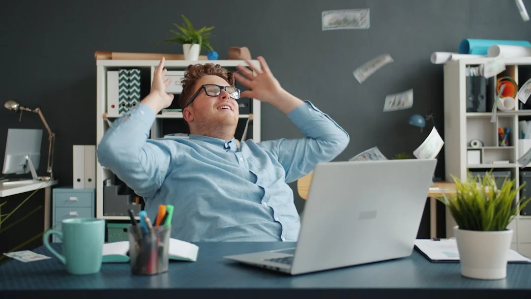 Un espace de travail moderne montrant des mains qui examinent des données marketing sur un ordinateur portable et des documents papier.